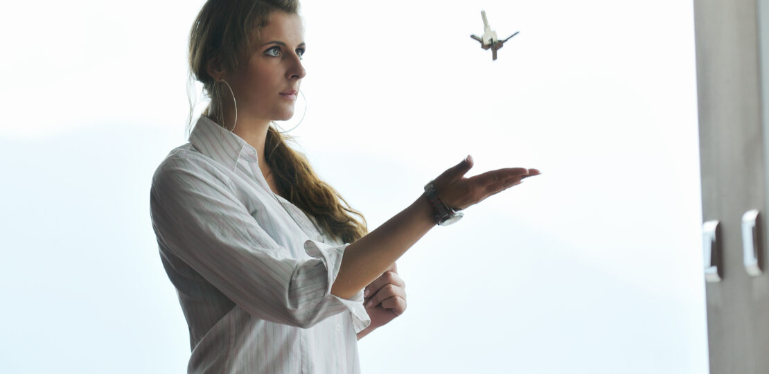 young woman throwing home keys in air