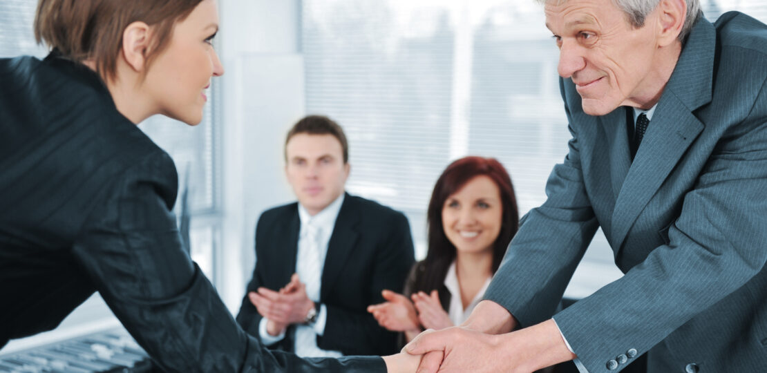 Young business woman passed on a job interview shaking hands with boss